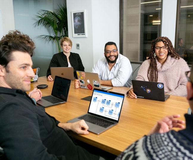A man in a meeting looking at a process map on his computer screen